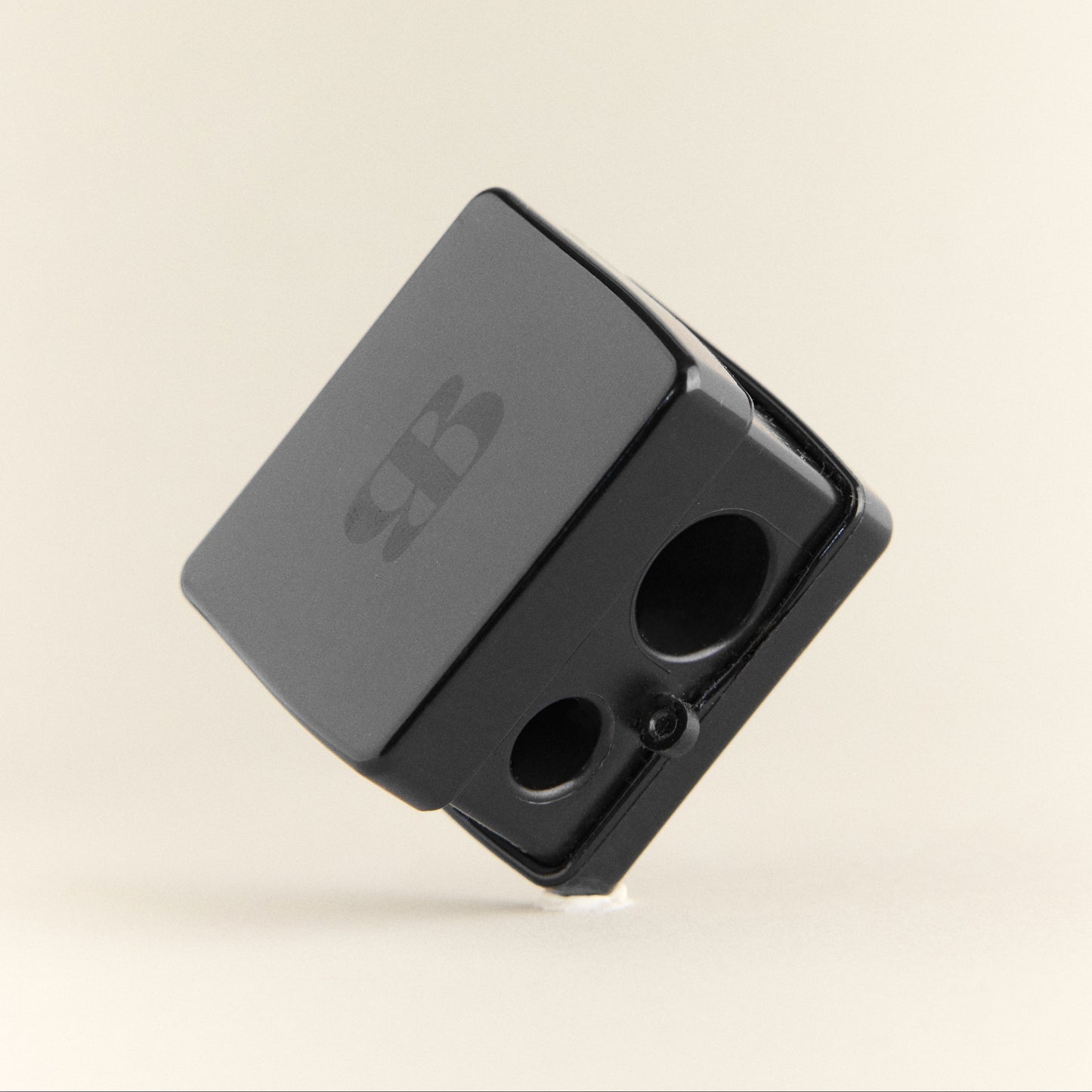 Black pencil sharpener on a beige background